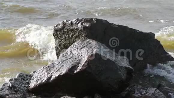 石头和白天海水的缓慢流动视频的预览图