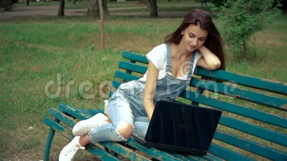 你笔记本电脑上公园里漂亮的女孩视频的预览图