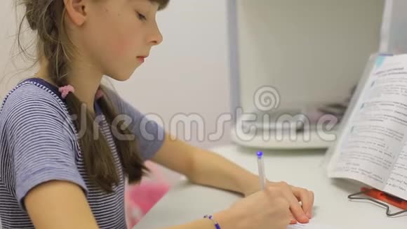 坐在桌子上做作业的少女视频的预览图