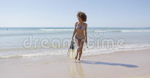 有脚蹼的女人在海滩上散步视频的预览图