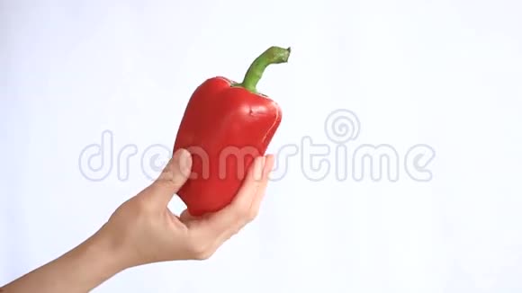 一个男人白色背景上拿着蔬菜的手保加利亚胡椒帕普利卡视频的预览图