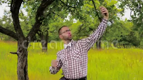 戴眼镜的男人待在草地上自拍视频的预览图