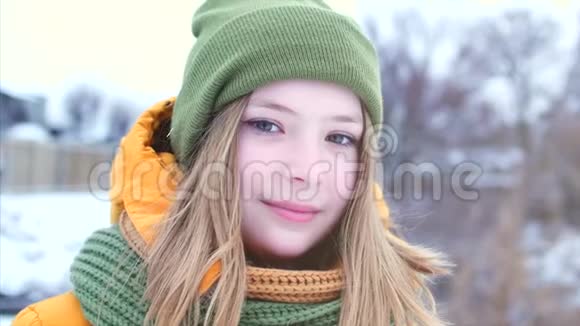 一个年轻漂亮的少女的肖像金发吹着风在户外享受冬天的日子视频的预览图
