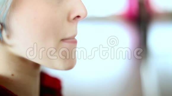 少女化了妆站在镜子前捏紧嘴唇抹上口红视频的预览图