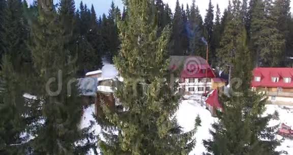 冬天一架无人机在森林中的房子附近飞行视频的预览图