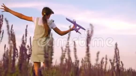 快乐女孩带着玩具飞机在花田上跑步孩子们玩玩具飞机少年梦想飞翔和视频的预览图