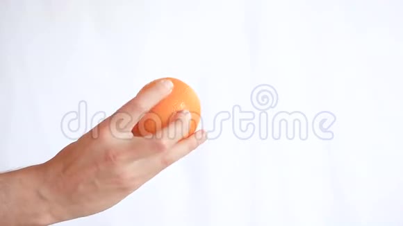 男人白色背景上的手拿着水果橙色视频的预览图