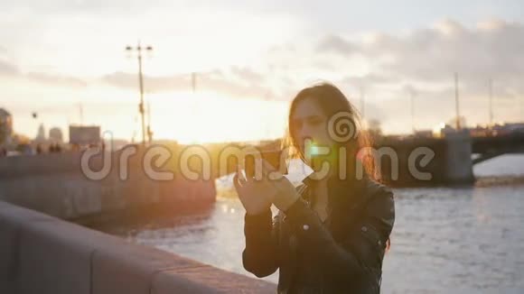 一个女孩自拍太阳落山在一个美妙的地方繁忙的道路一座桥一条河的背景慢的莫视频的预览图