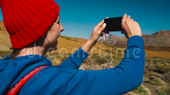 活跃的徒步旅行者女性徒步旅行在Teide国家公园并在智能手机上制作照片景观加那利群岛视频的预览图