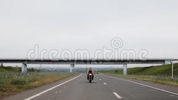 肌肉男沿着马路骑摩托车视频的预览图