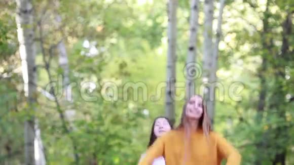 在大自然的日子里两个快乐的女朋友把蓝色和红色的布扔了视频的预览图