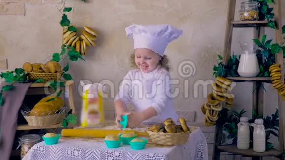 可爱的孩子在厨房做蛋糕的女孩视频的预览图