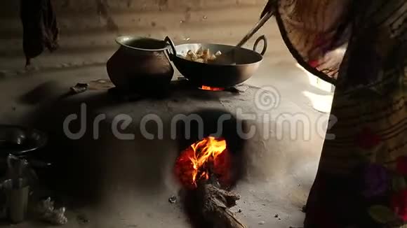 印度女人正在石炉里煮土豆只需双手火焰在炉子里视频的预览图