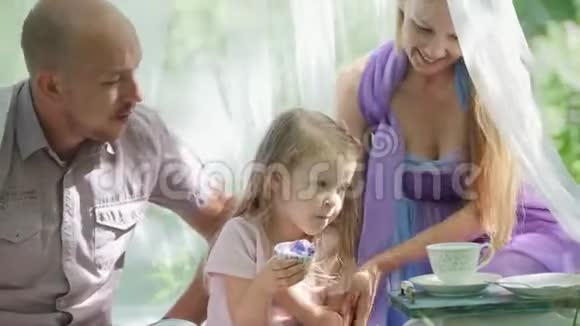 在绿色公园户外玩得开心的家庭母亲父亲和女儿视频的预览图
