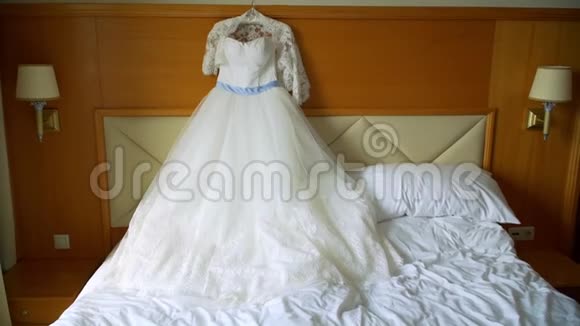 优雅的婚纱躺在酒店房间的床上视频的预览图