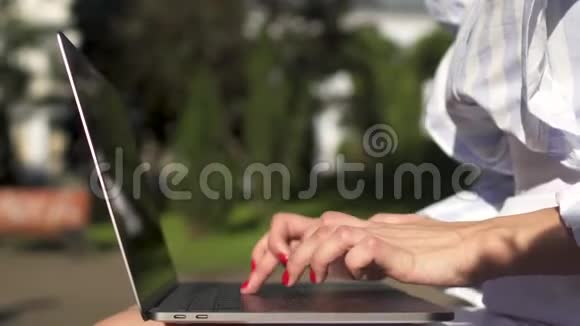 在公园的笔记本电脑里工作的女人视频的预览图