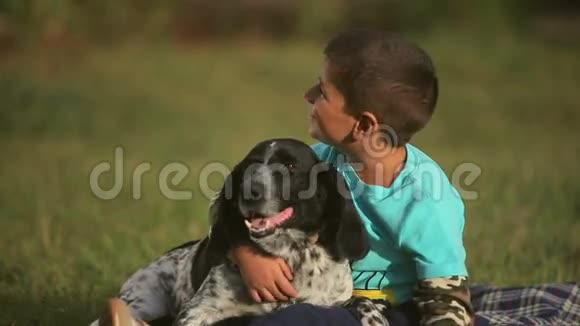 草地上的男孩抱着狗视频的预览图