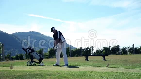 仍然是一个男子高尔夫球手打一个白色高尔夫球与高尔夫球杆和视频的预览图