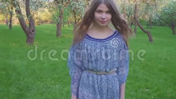 诱惑着走在苹果园里的年轻女子春暖花开一个美丽女孩的肖像视频的预览图