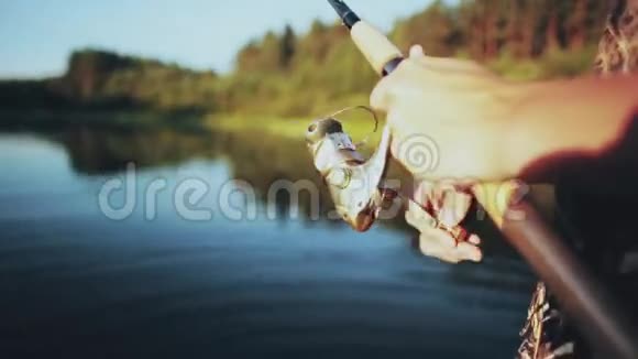 近景男性手握鱼竿年轻的渔夫用旋转的卷轴捻杆视频的预览图