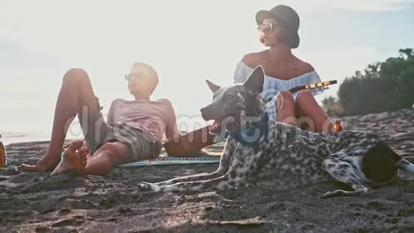 年轻夫妇在海滩上玩得很开心岛上的周末年轻夫妇在海滩上用吉他唱歌他们的滑稽视频的预览图