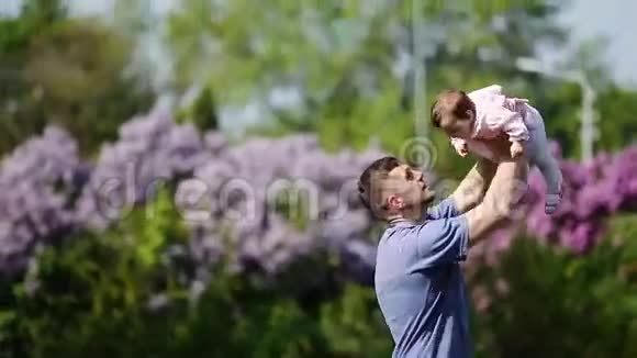 快乐的父亲抱着小女婴在公园里一起玩视频的预览图