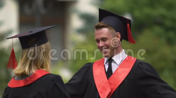 快乐的男人祝贺和拥抱年轻的女人毕业日成就视频的预览图