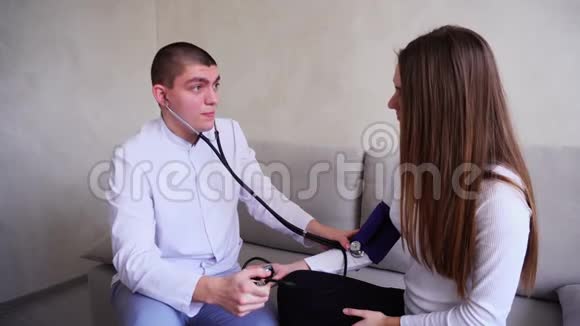 医生在医院明亮的办公室里坐在沙发上测量压力女性患者的音调视频的预览图