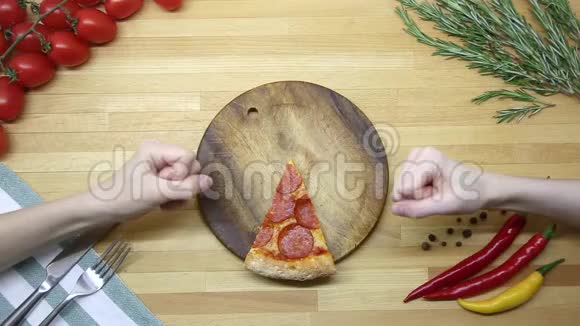 手在玩石头纸剪刀从木制桌子上赢得披萨切割上景视频的预览图