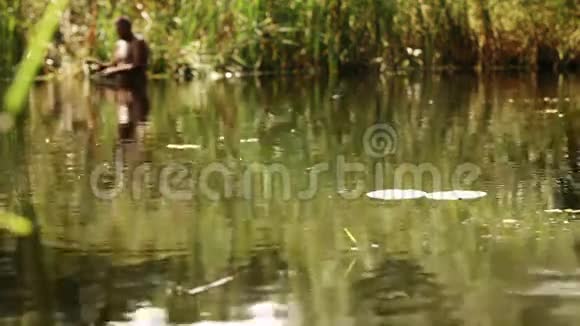 度假的人拿着鱼竿站在水里钓鱼视频的预览图