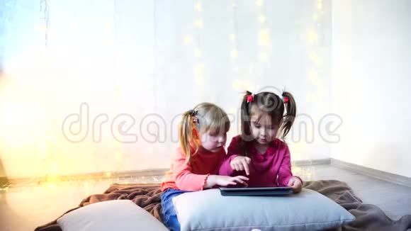 小女孩参与使用平板电脑坐在明亮的房间里墙上有花环视频的预览图
