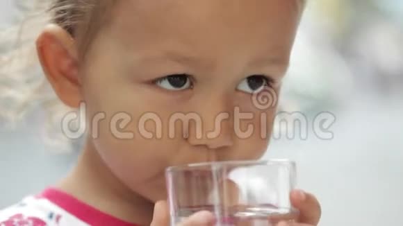 一个小可爱的女孩用杯子喝纯净水视频的预览图