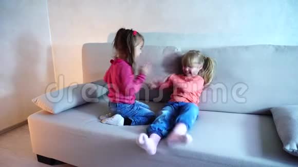 两个姐妹在客厅的沙发上玩耍视频的预览图