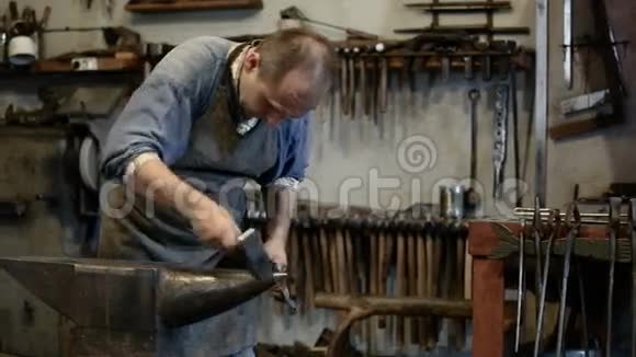 男铁匠在铁匠铺里锻造金属视频的预览图