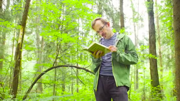 一个森林里的生态学家在检查植物视频的预览图