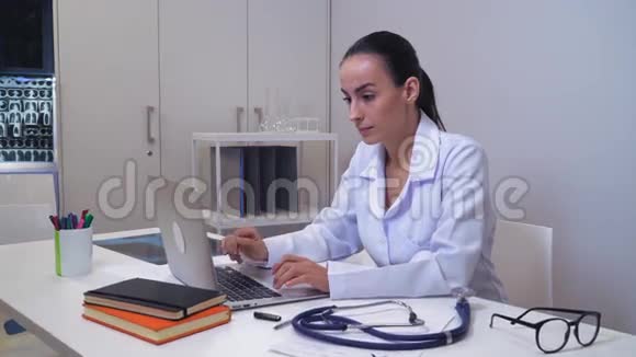 女性医学博士在诊所的笔记本电脑上上网视频的预览图