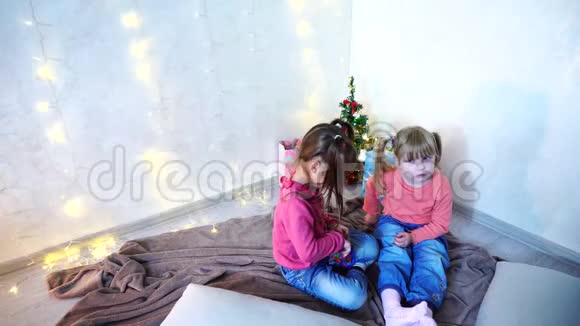 活泼好动的女孩子在墙上坐在地上地毯上嬉笑打闹视频的预览图