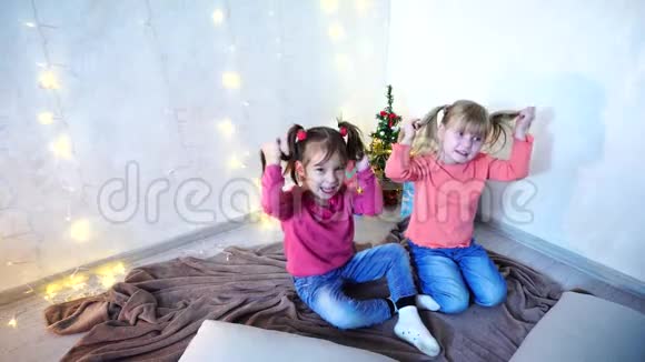 活泼好动的女孩子在墙上坐在地上地毯上嬉笑打闹视频的预览图