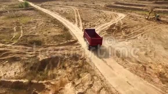 卡车在采石场道路上行驶场景农村黄泥路自卸车行驶的俯视图大型卡车视频的预览图