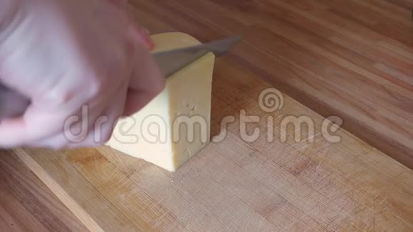 女人用手在木板上切割奶酪视频的预览图