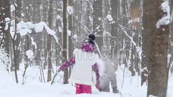 两个小女孩在冬天的森林里玩雪视频的预览图