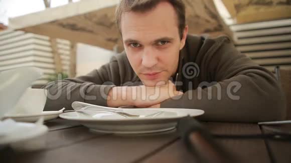 一个人在咖啡馆的桌子旁等着他吃饭空盘子视频的预览图