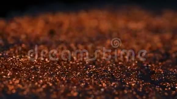 抽象的五颜六色的红金沙有机地流动在五颜六色的液体在宏观黑色的背景视频的预览图