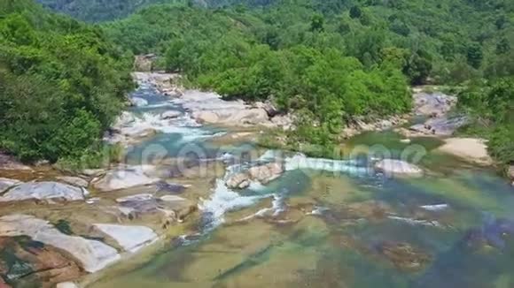 无人机在湍急的岩石河岸上飞上狭窄的河流视频的预览图