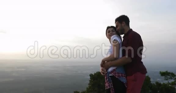 情侣在山顶拥抱举起双手拉丁男人和女人享受自由之风视频的预览图