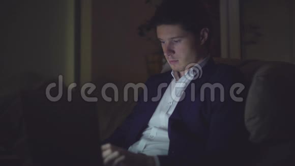 夜间使用笔记本电脑的肖像男子视频的预览图