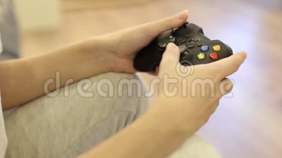 一个玩电子游戏的年轻女子手上的特写镜头视频的预览图