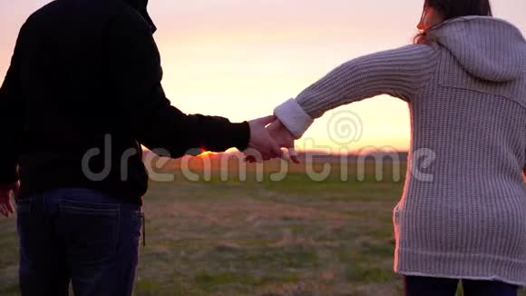 一对年轻夫妇手牵着手在广阔的田野里奔跑在户外玩得很开心视频的预览图