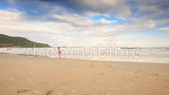 小女孩与猪尾男孩玩球沙滩沙滩视频的预览图