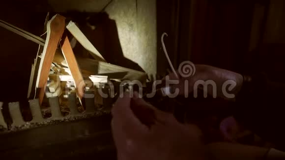 在壁炉里用火柴和木棍生火的人高清特写慢动作视频的预览图
